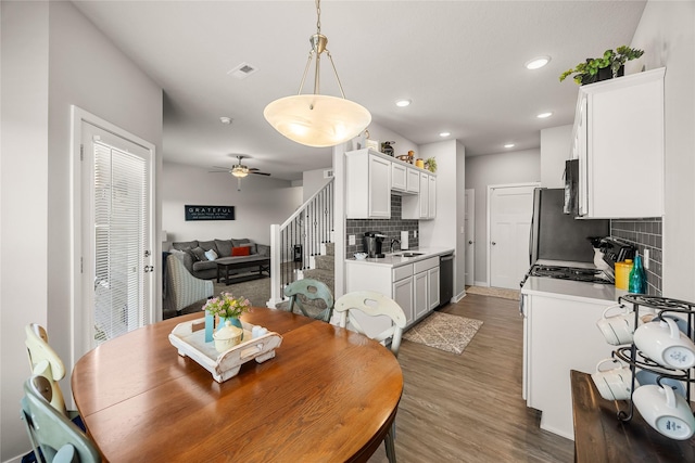 dining area with dark hardwood / wood-style flooring, ceiling fan, and sink