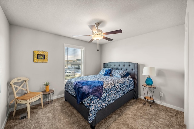 bedroom with ceiling fan, carpet floors, and a textured ceiling