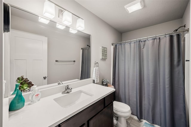 bathroom featuring a shower with curtain, vanity, toilet, and a textured ceiling