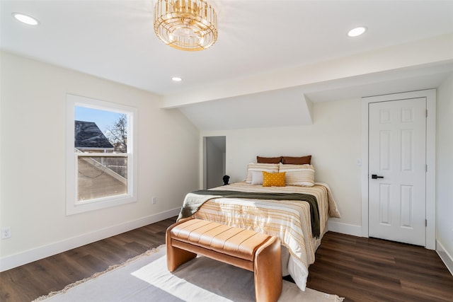 bedroom with dark hardwood / wood-style flooring, a chandelier, and vaulted ceiling