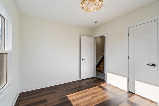 unfurnished bedroom with dark wood-type flooring and multiple windows