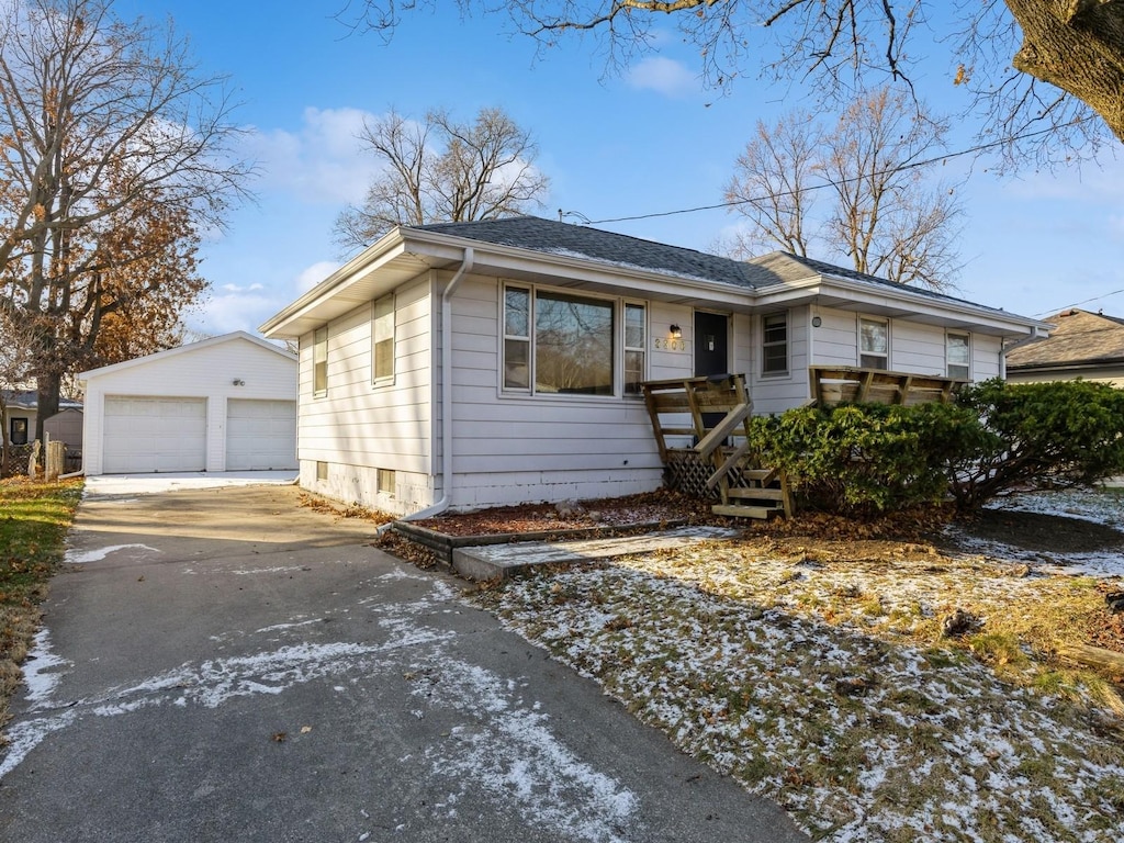 view of front of house with a garage and an outbuilding