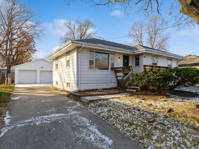 view of front of house with a garage and an outbuilding