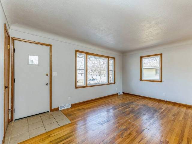 foyer entrance featuring a textured ceiling and hardwood / wood-style flooring