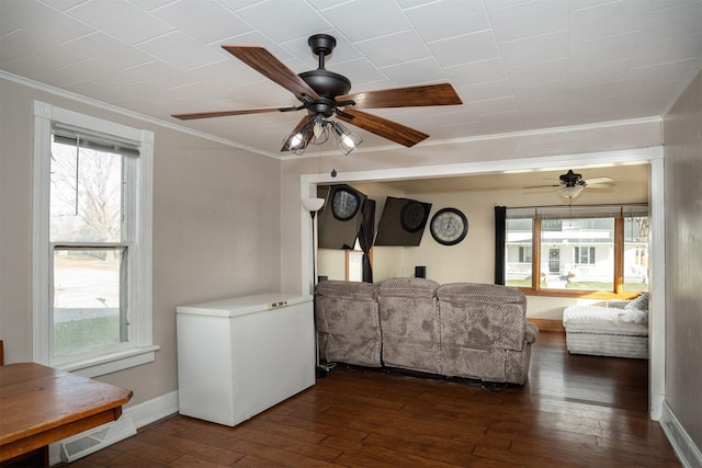 living room featuring dark hardwood / wood-style floors, ceiling fan, and crown molding