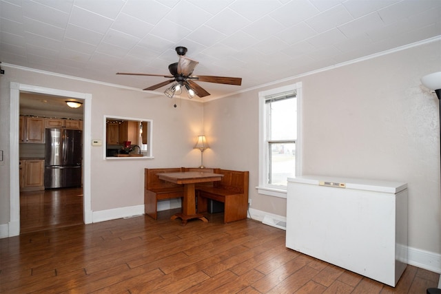 dining area with crown molding, dark hardwood / wood-style flooring, and ceiling fan