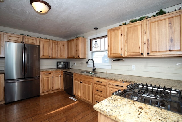 kitchen featuring dark hardwood / wood-style flooring, light stone counters, sink, black appliances, and hanging light fixtures