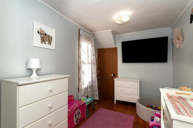 bedroom with dark hardwood / wood-style flooring and ornamental molding