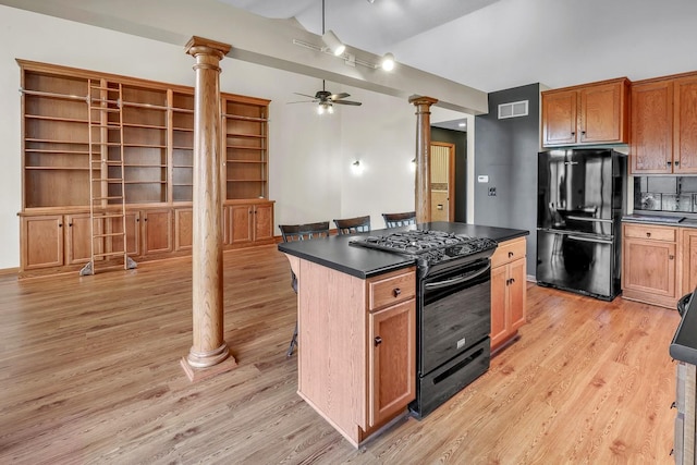 kitchen featuring black appliances, ceiling fan, a center island, and ornate columns