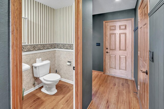 bathroom featuring hardwood / wood-style floors, a textured ceiling, and toilet