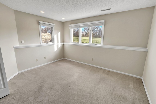 carpeted spare room with a textured ceiling