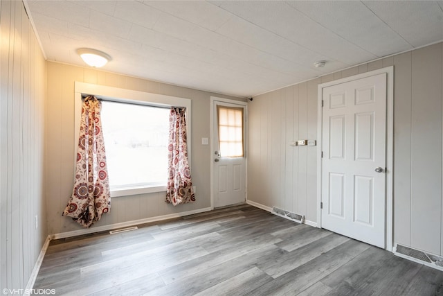 entryway featuring wood walls and light hardwood / wood-style flooring