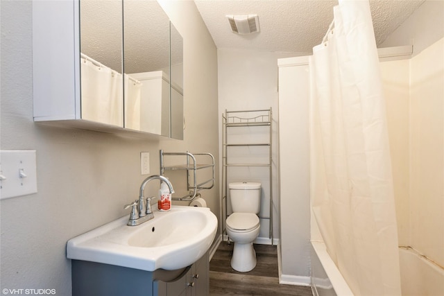 full bathroom featuring vanity, a textured ceiling, wood-type flooring, shower / bathtub combination with curtain, and toilet