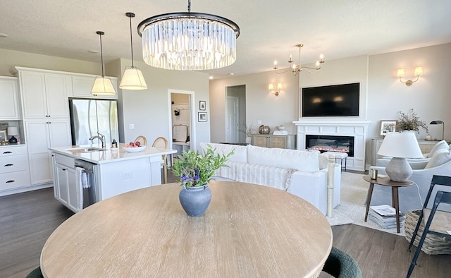 dining space featuring an inviting chandelier, dark hardwood / wood-style flooring, sink, and a textured ceiling