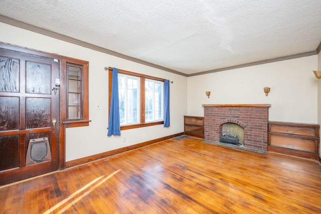 unfurnished living room featuring a fireplace, a textured ceiling, hardwood / wood-style flooring, and ornamental molding