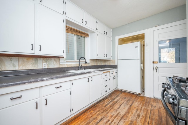 kitchen with white cabinets, white fridge, sink, and stainless steel range