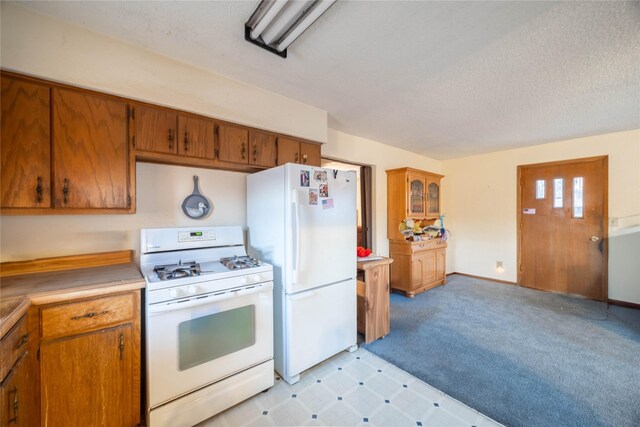 kitchen featuring a textured ceiling and white appliances