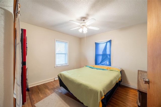 bedroom with a textured ceiling, dark hardwood / wood-style flooring, and ceiling fan