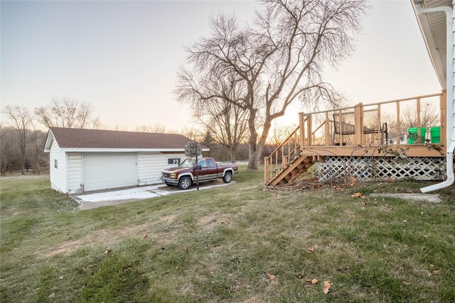 yard at dusk with an outbuilding, a garage, and a wooden deck