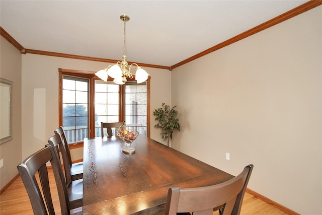 dining area featuring light wood-type flooring, ornamental molding, and an inviting chandelier