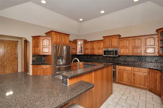 kitchen with lofted ceiling, backsplash, and appliances with stainless steel finishes