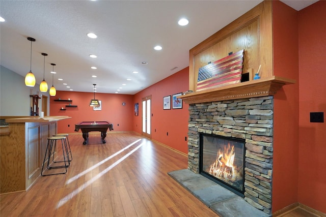 recreation room with a fireplace, billiards, and light wood-type flooring