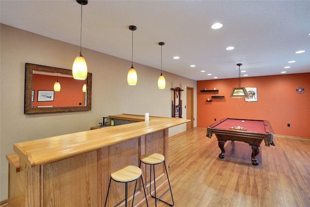 recreation room featuring light hardwood / wood-style floors, pool table, and bar area