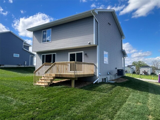 rear view of property featuring a lawn, a deck, and central air condition unit