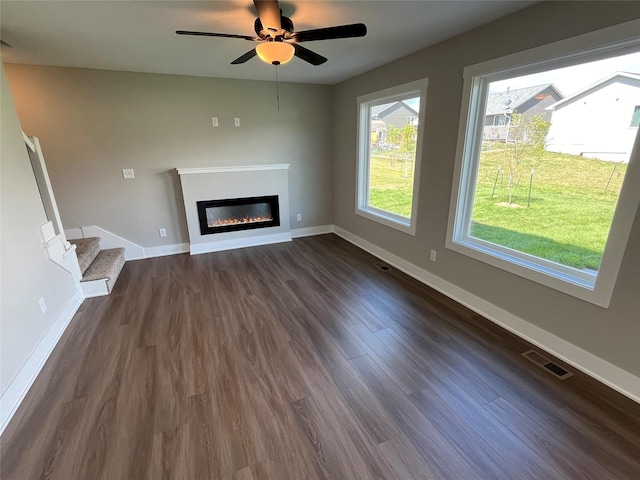 unfurnished living room featuring dark hardwood / wood-style floors and ceiling fan