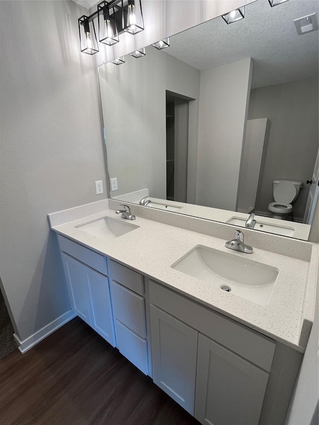 bathroom with vanity, toilet, and hardwood / wood-style floors