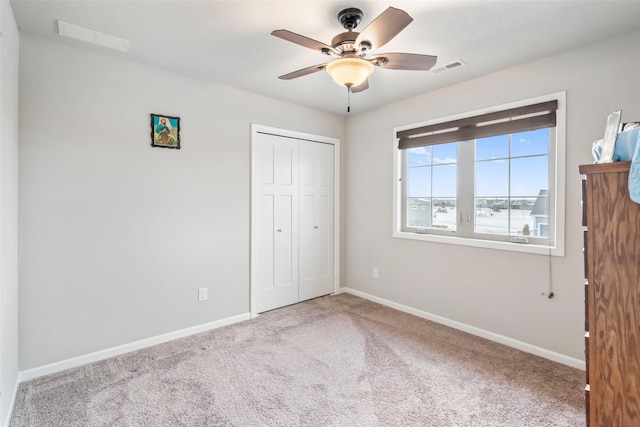 unfurnished bedroom featuring ceiling fan, a closet, and light carpet