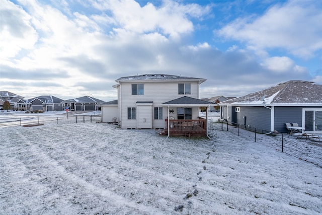 snow covered house featuring a deck