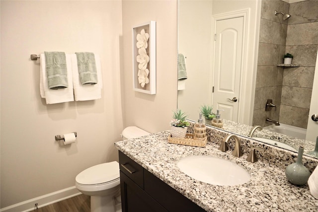 full bathroom with vanity, toilet, tiled shower / bath, and hardwood / wood-style flooring