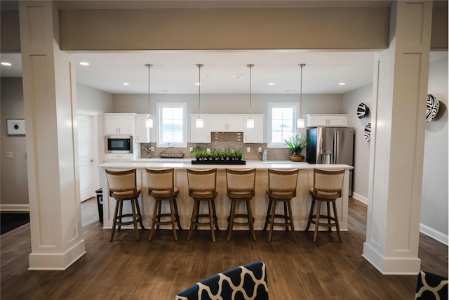 kitchen with decorative light fixtures, white cabinetry, dark hardwood / wood-style floors, and a large island