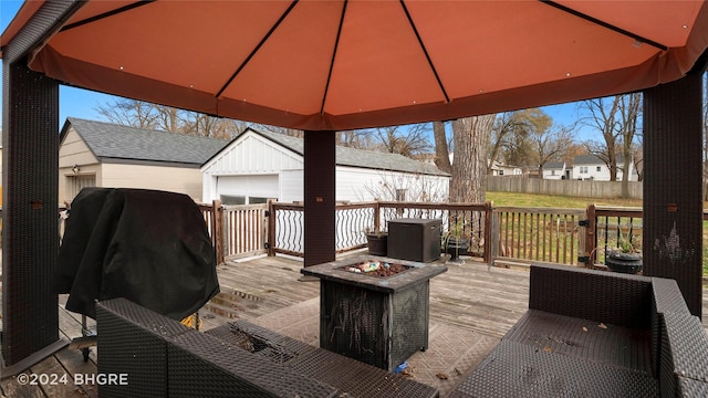 deck featuring a gazebo, an outbuilding, and an outdoor fire pit