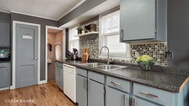 kitchen with crown molding, sink, gray cabinets, light wood-type flooring, and tasteful backsplash