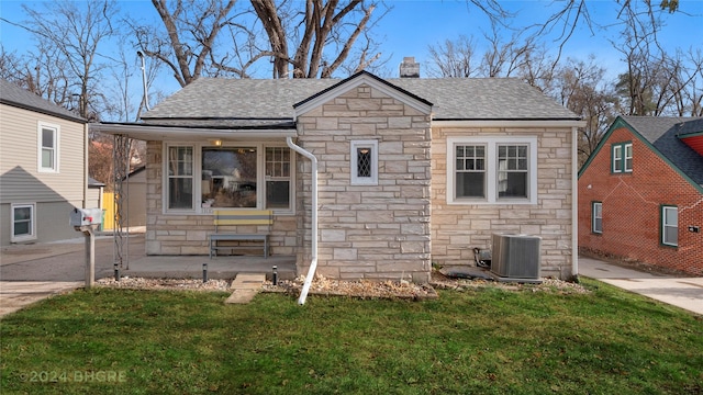 bungalow with a front lawn and cooling unit