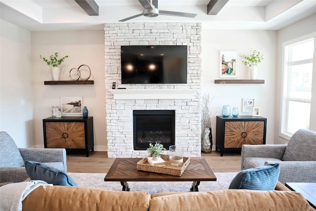 living room with ceiling fan, a fireplace, a healthy amount of sunlight, and light hardwood / wood-style floors