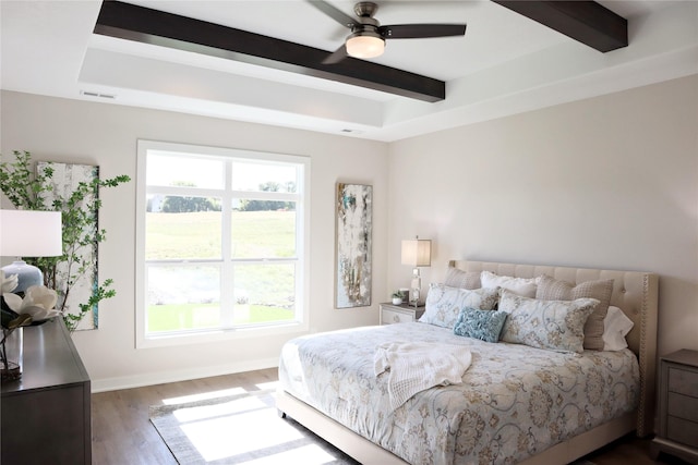 bedroom with beamed ceiling, ceiling fan, and dark hardwood / wood-style flooring