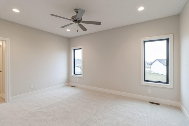 spare room featuring light carpet and ceiling fan