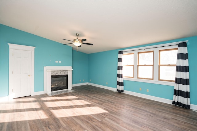 unfurnished living room with ceiling fan, a fireplace, and hardwood / wood-style flooring