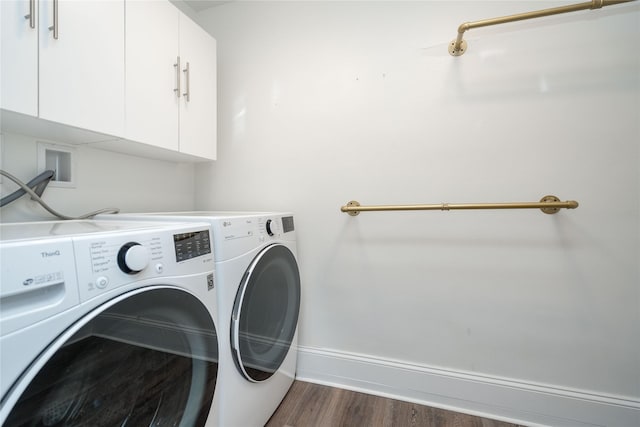 clothes washing area featuring dark hardwood / wood-style floors, cabinets, and washing machine and clothes dryer