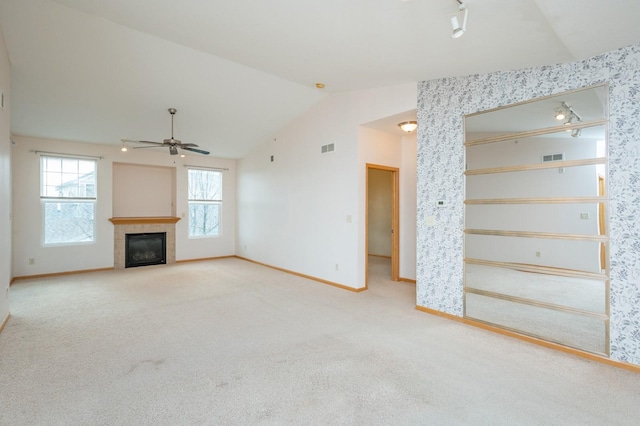 unfurnished living room featuring a fireplace, carpet, ceiling fan, and lofted ceiling