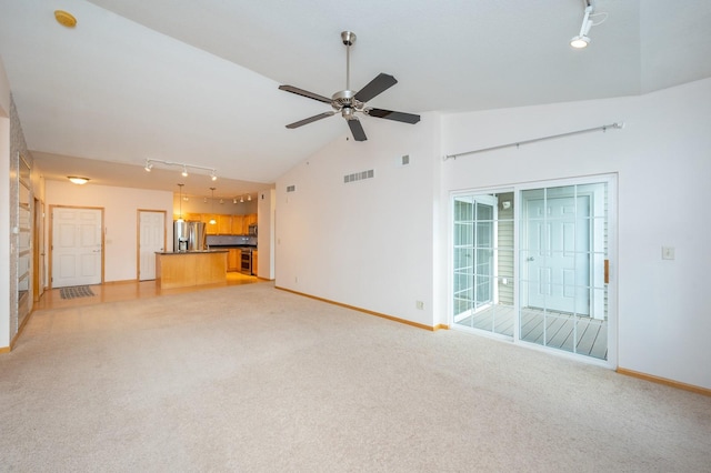 unfurnished living room with light carpet, rail lighting, high vaulted ceiling, and ceiling fan