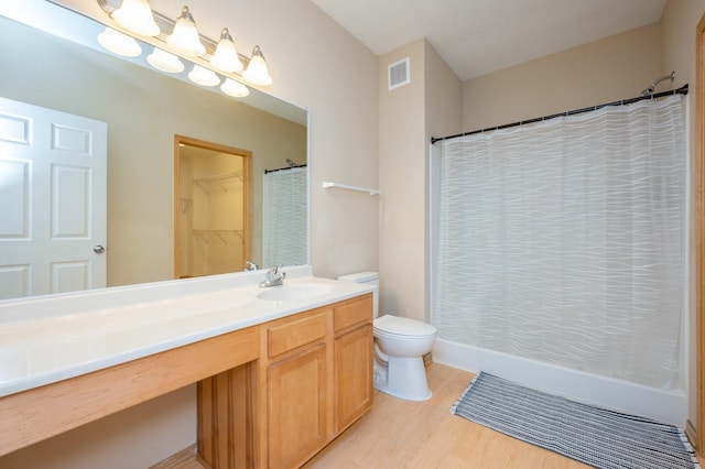 bathroom with wood-type flooring, vanity, and toilet