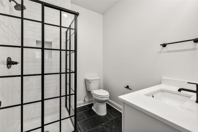 bathroom with tiled shower, vanity, and toilet