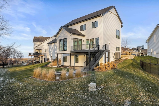 rear view of property featuring central AC, a lawn, and a deck