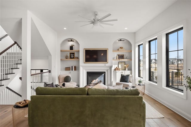 living room featuring built in features and light hardwood / wood-style floors