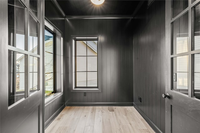 empty room featuring wooden walls and light wood-type flooring