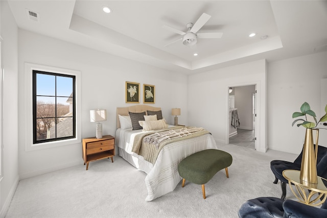 carpeted bedroom featuring ceiling fan and a tray ceiling